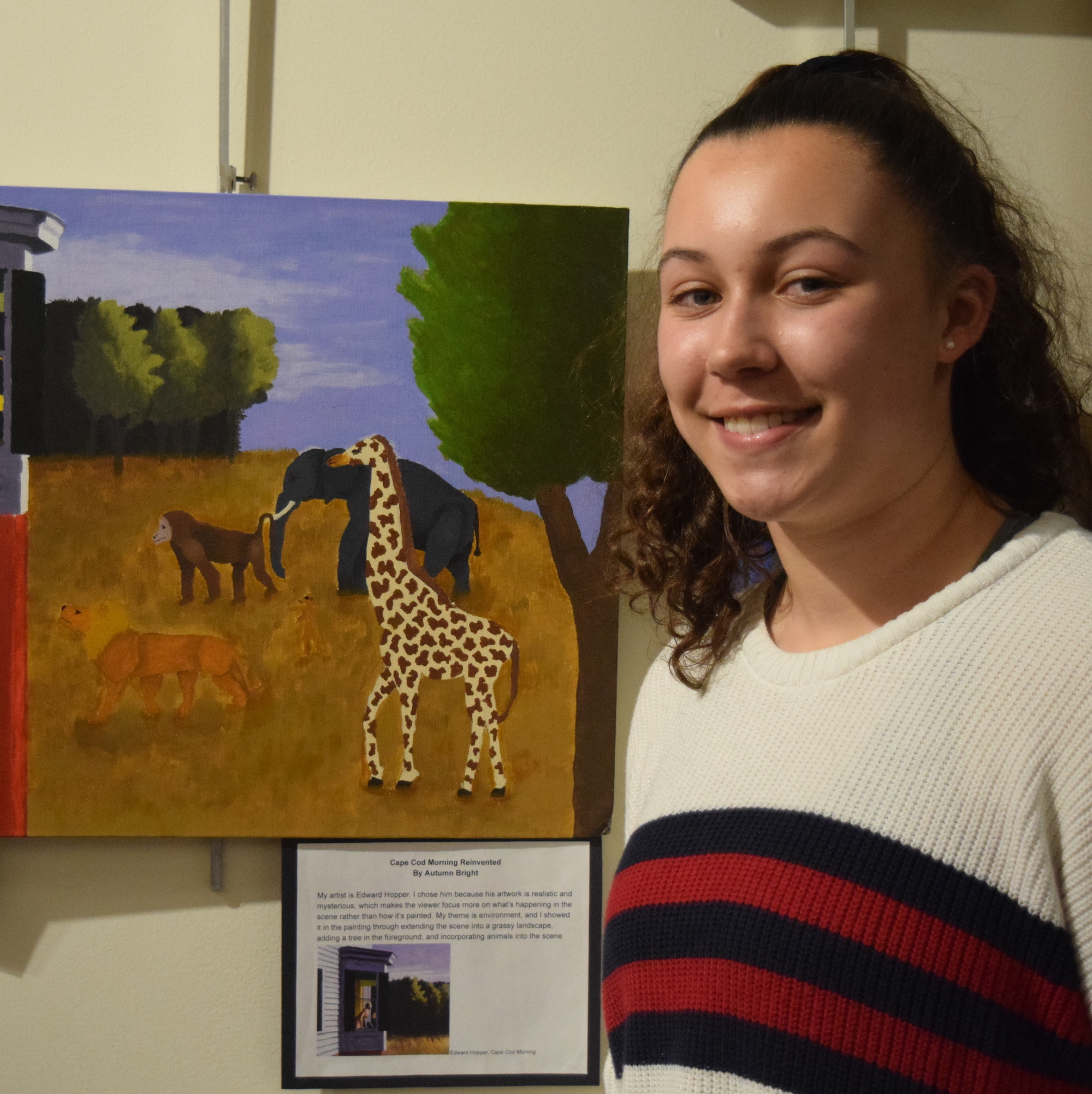 A student stands by her artwork displayed at the San Mateo County Office of Education.